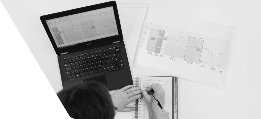 Pessoa em espaço de trabalho anotando com notebook